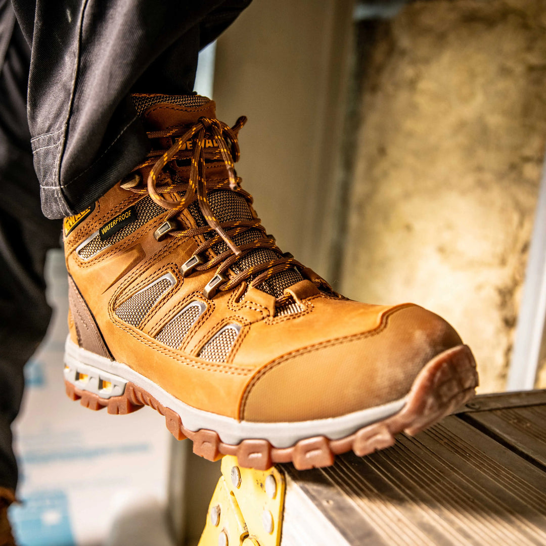 DEWALT Grader Men's Lightweight Work Boot Wheat, 3/4 Right View Model Stepping On Ladder