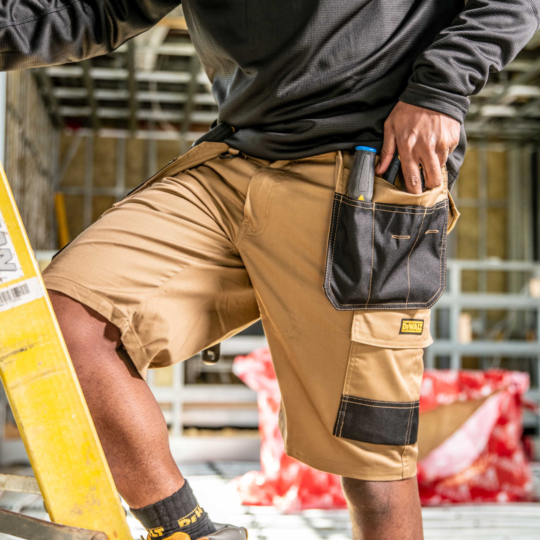 DEWALT ProTradesman Men's Tan Poly Cotton, Holster Pocket, Stretch Work Shorts Front Left View Model on Ladder